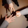 Three people in formal attire (B1A4 members) making a circle with their hands against a brown background, with 'SET' text on right-hand side of photo. 