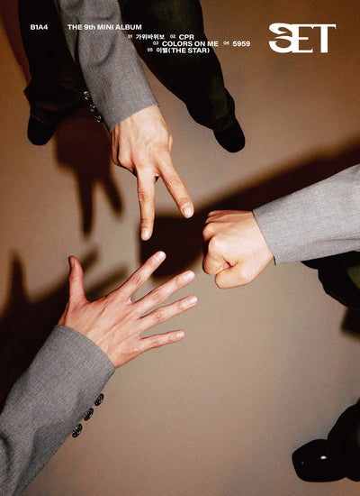 Three people in formal attire (B1A4 members) making a circle with their hands against a brown background, with 'SET' text on right-hand side of photo. 