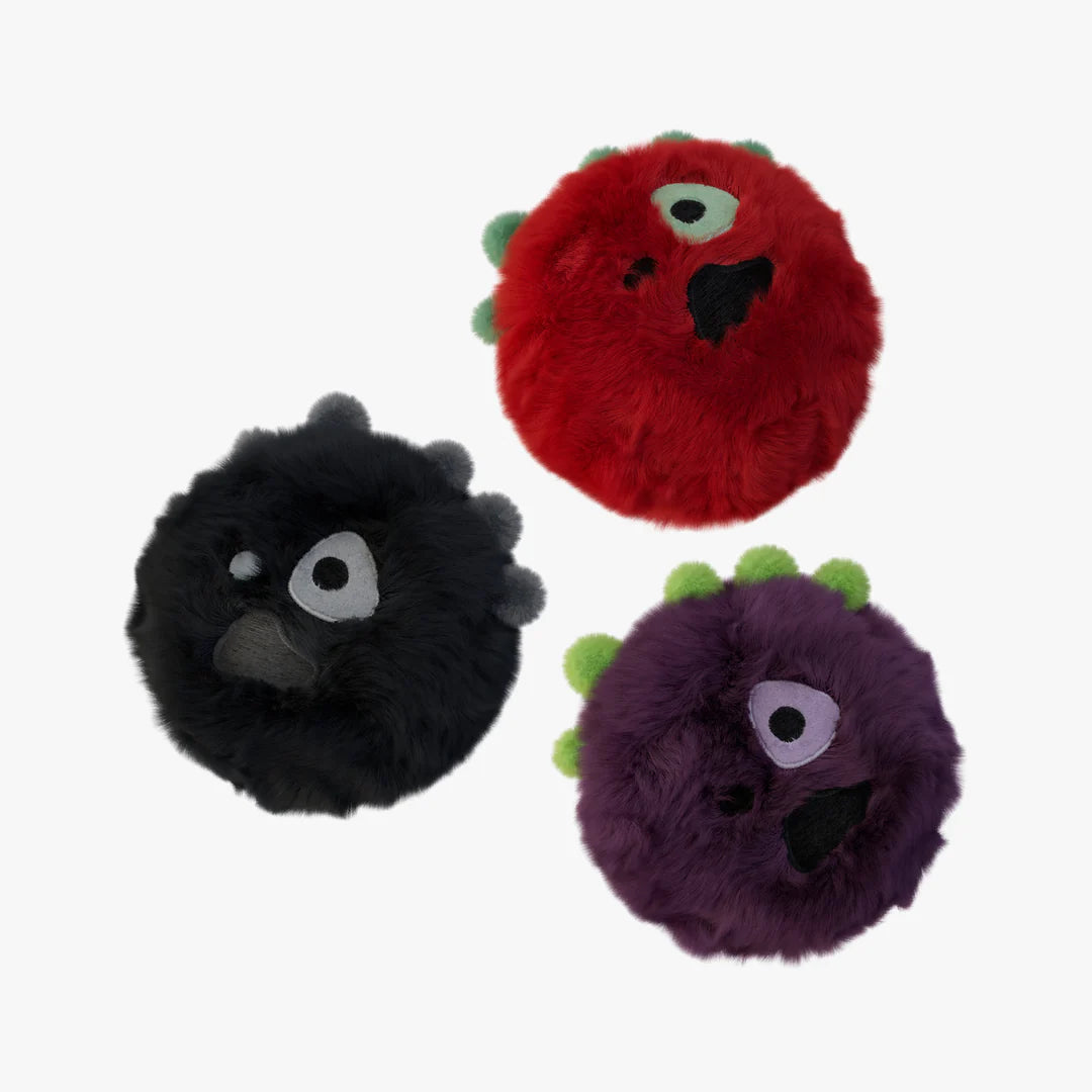 Three fuzzy monster toys in red, black, and purple on a white background included in CORTIS's greengreen album