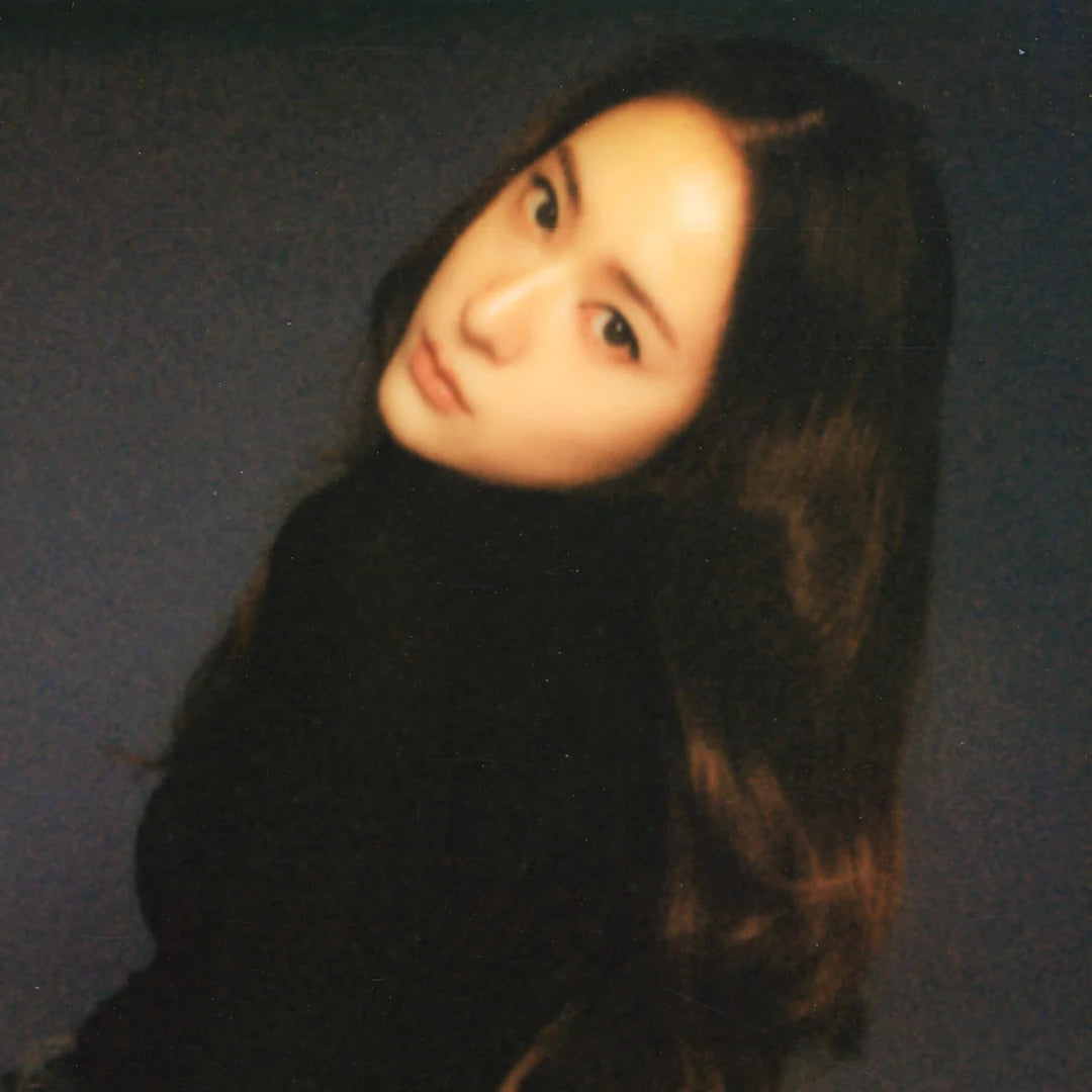 A photo of KRYSTAL wearing a black turtleneck against a dark background