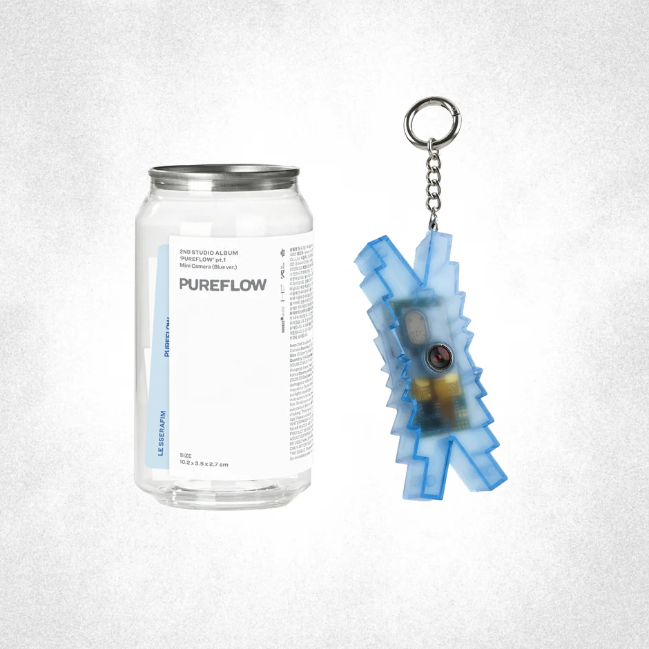 LE SSERAFIM's 2nd studio album packaging with a transparent bottle with the text 'PUREFLOW' written on it and a blue camera in the form of their logo on a white background