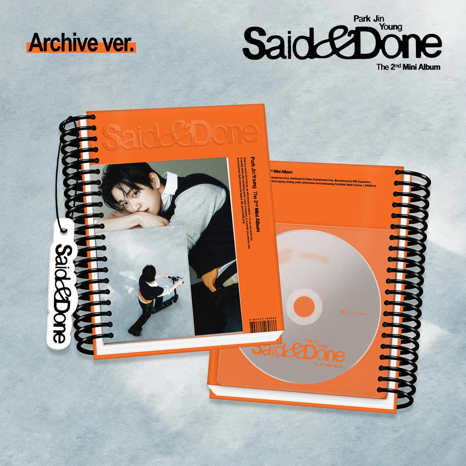 Orange spiral notebook packaging of Park Jin Young's 2nd mini album on a bluish background