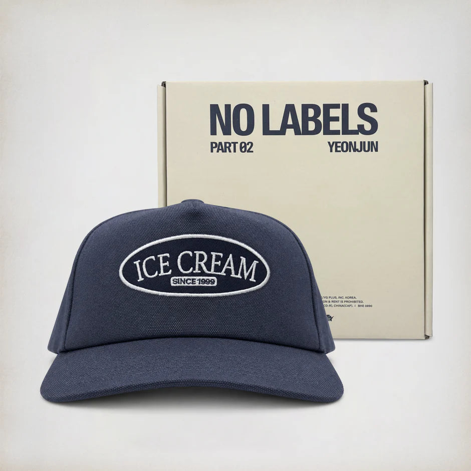 Navy blue cap with 'Ice Cream Since 1980' text in front of a beige box labeled 'NO LABELS PART 02 YEONJUN'.